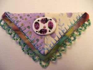 Cute little purple lady bugs on spring-like fabric base 